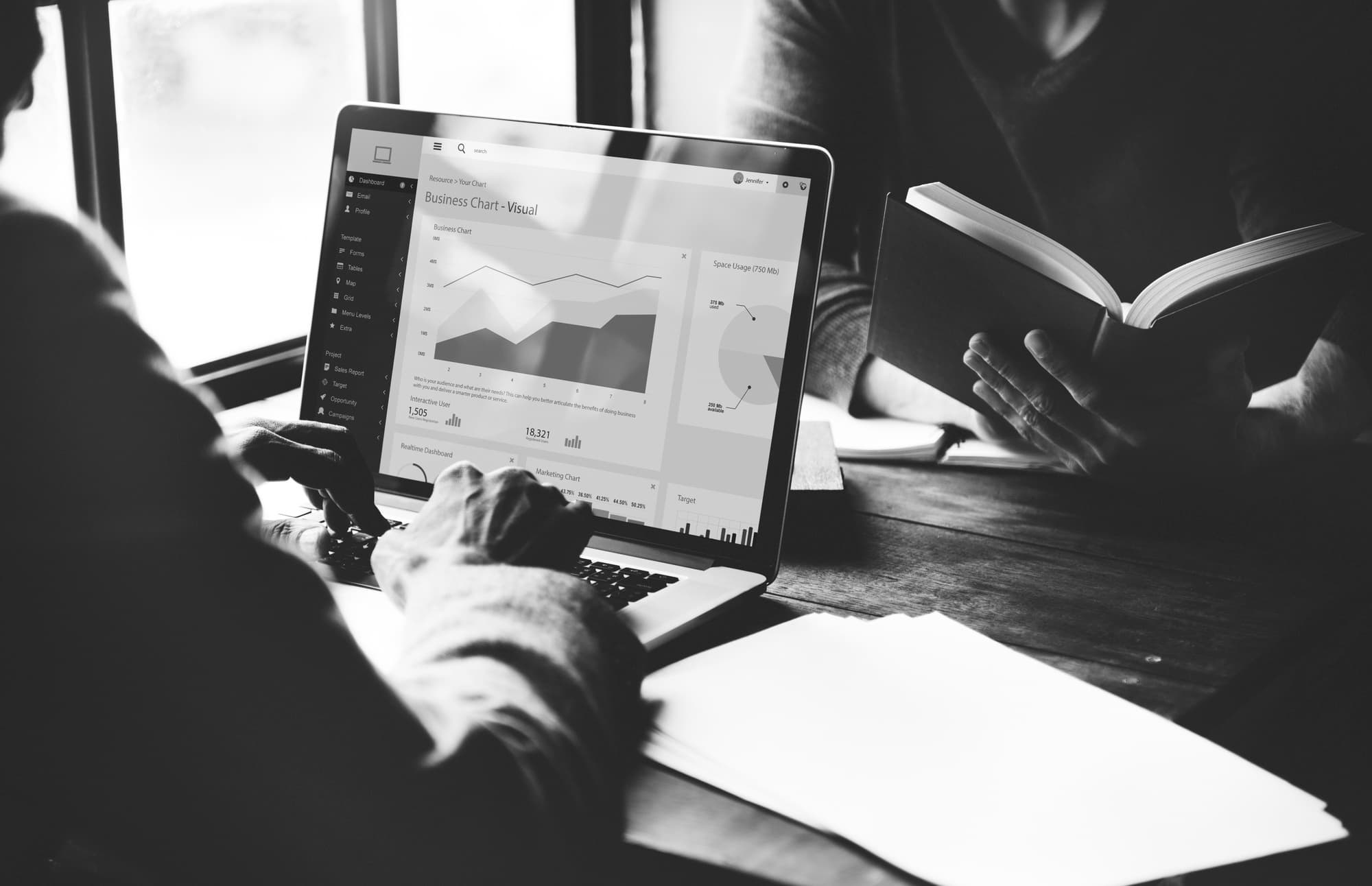 A product analytics dashboard beside an open notebook